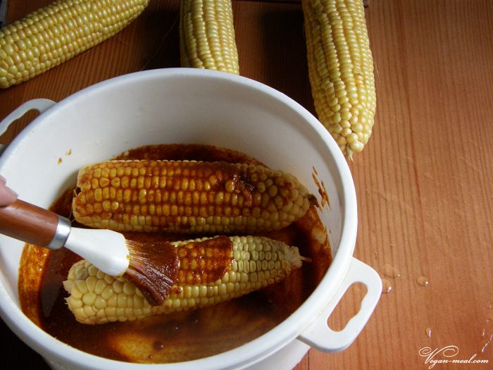 Кулинарной кистью нанести смесь из масла и специй на кукурузу