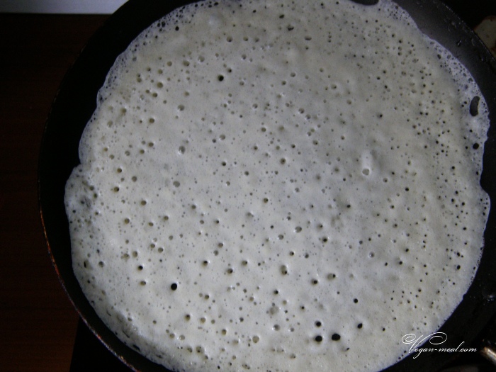 дрожжевое блинное тесто быстро вылить на сковороду, распределяя по всей поверхности